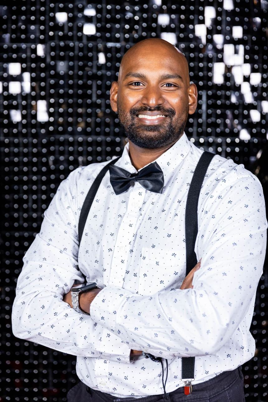 Pren Moodley, arms folded, in a shirt, bow tie and braces